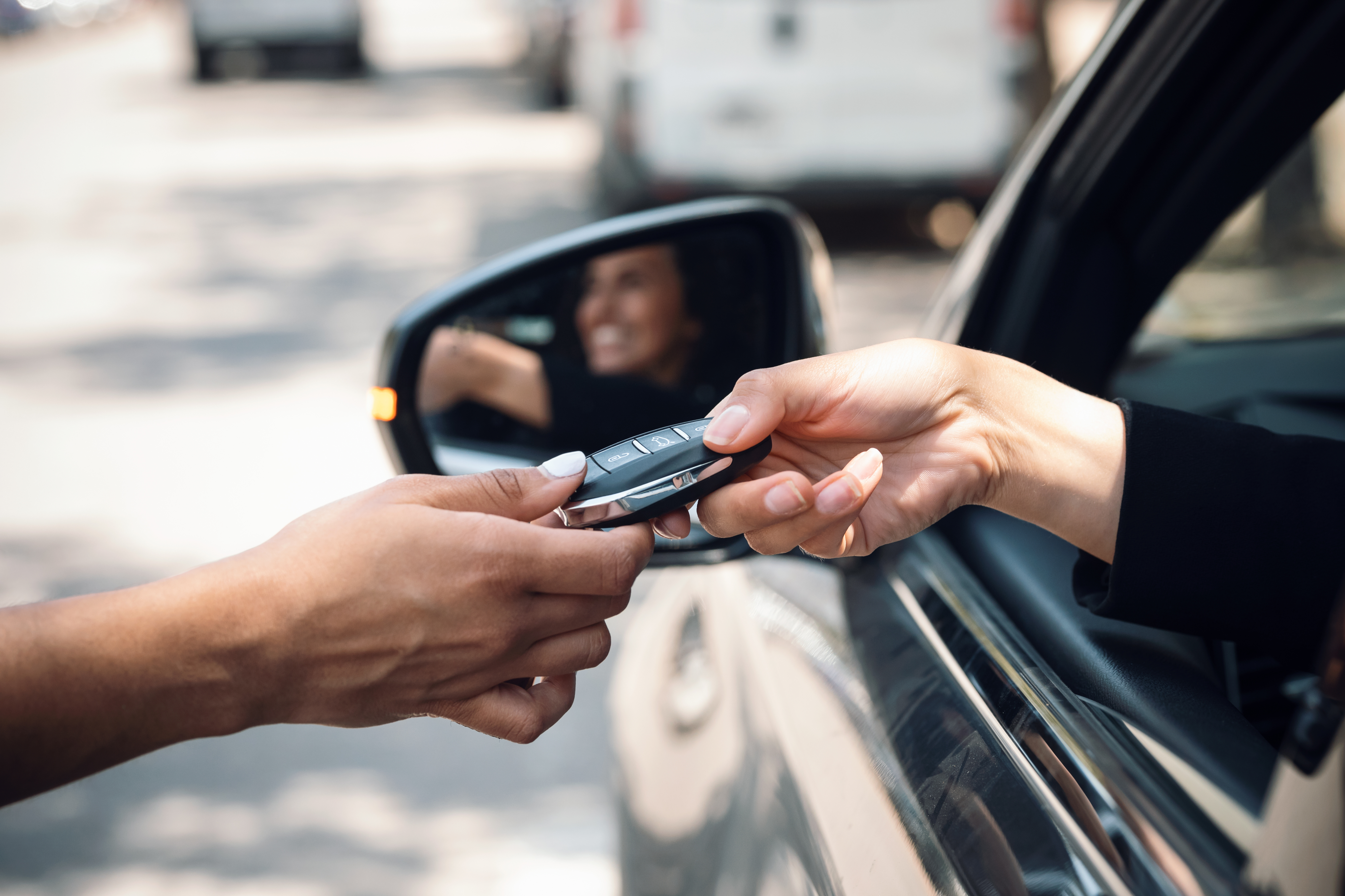 a woman is being handed the keys to her newly purchased used car